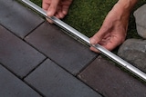 Mains installant une bordure.