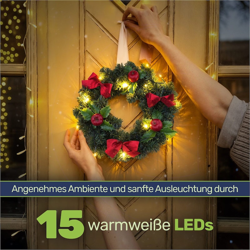 Ein Kranz mit roten Schleifen und Lichtern.
