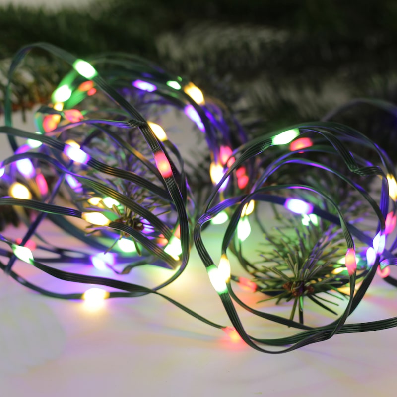 Lichterkette mit bunten Lichtern auf Tannenzweigen.