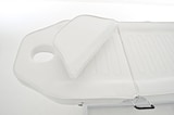 Ein weißer Massagetisch mit Kopfstütze.