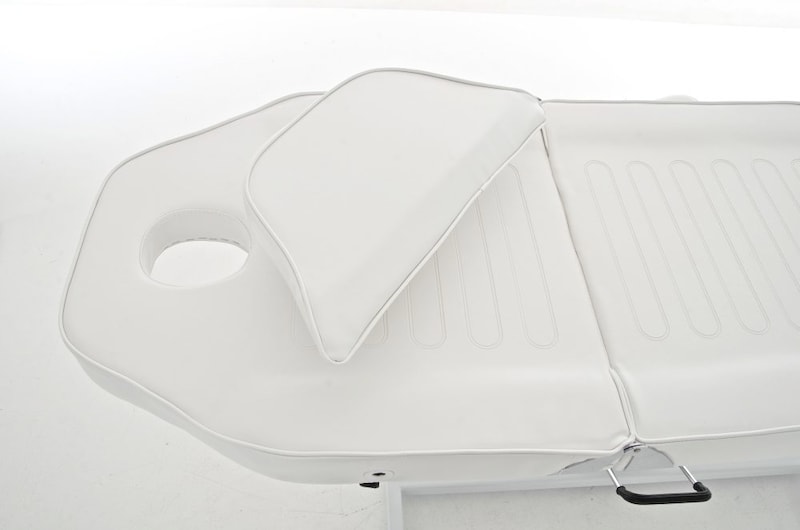 Ein weißer Massagetisch mit Kopfstütze.