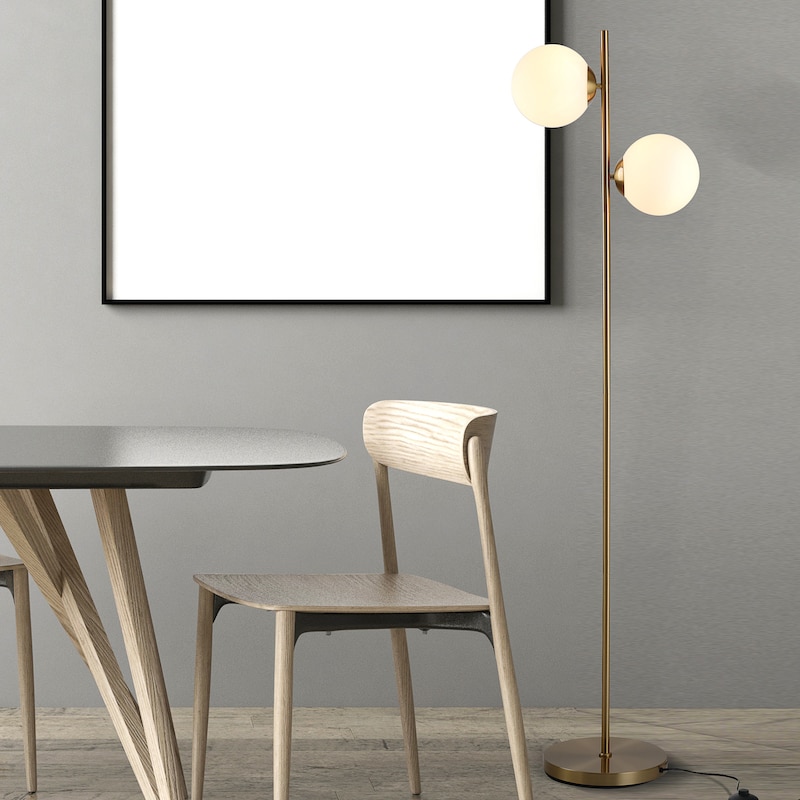 Ein moderner goldener Stehlampe mit zwei Kugeln.
