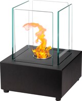 Ein schwarzer Tischkamin mit Glaswänden und Flammen.