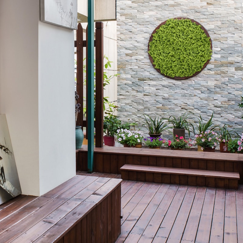 Un colgante de pared verde redondo con plantas.