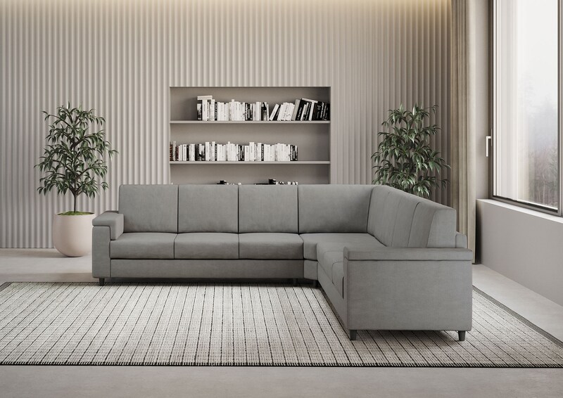 Divano angolare grigio con libreria sullo sfondo.