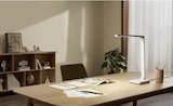 Ein moderner Schreibtisch mit Lampe und Büromaterial.