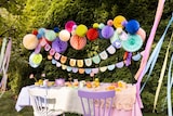 Eine bunte Partydekoration mit Girlanden und Pompons.