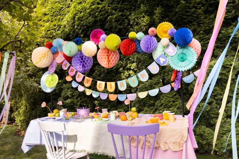 Eine bunte Partydekoration mit Girlanden und Pompons.
