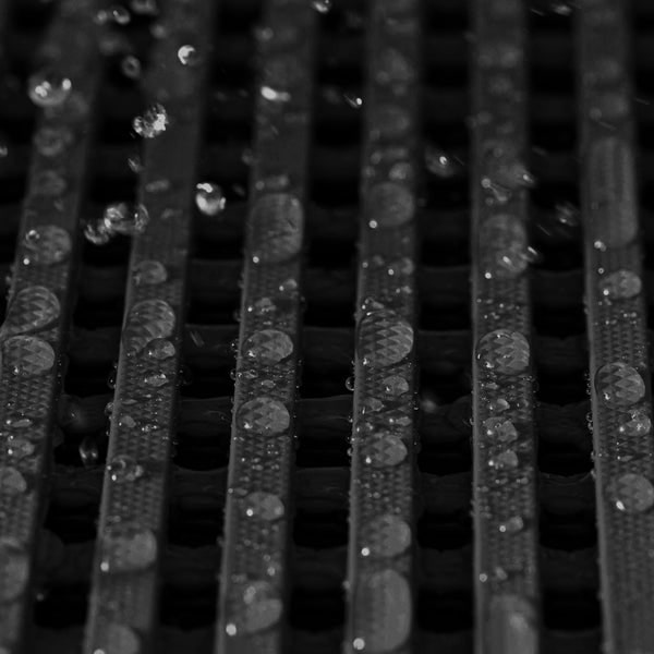 Wassertropfen auf einer geriffelten Oberfläche.