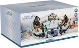 Eine beleuchtete Weihnachtsszene mit einer Eisbahn.